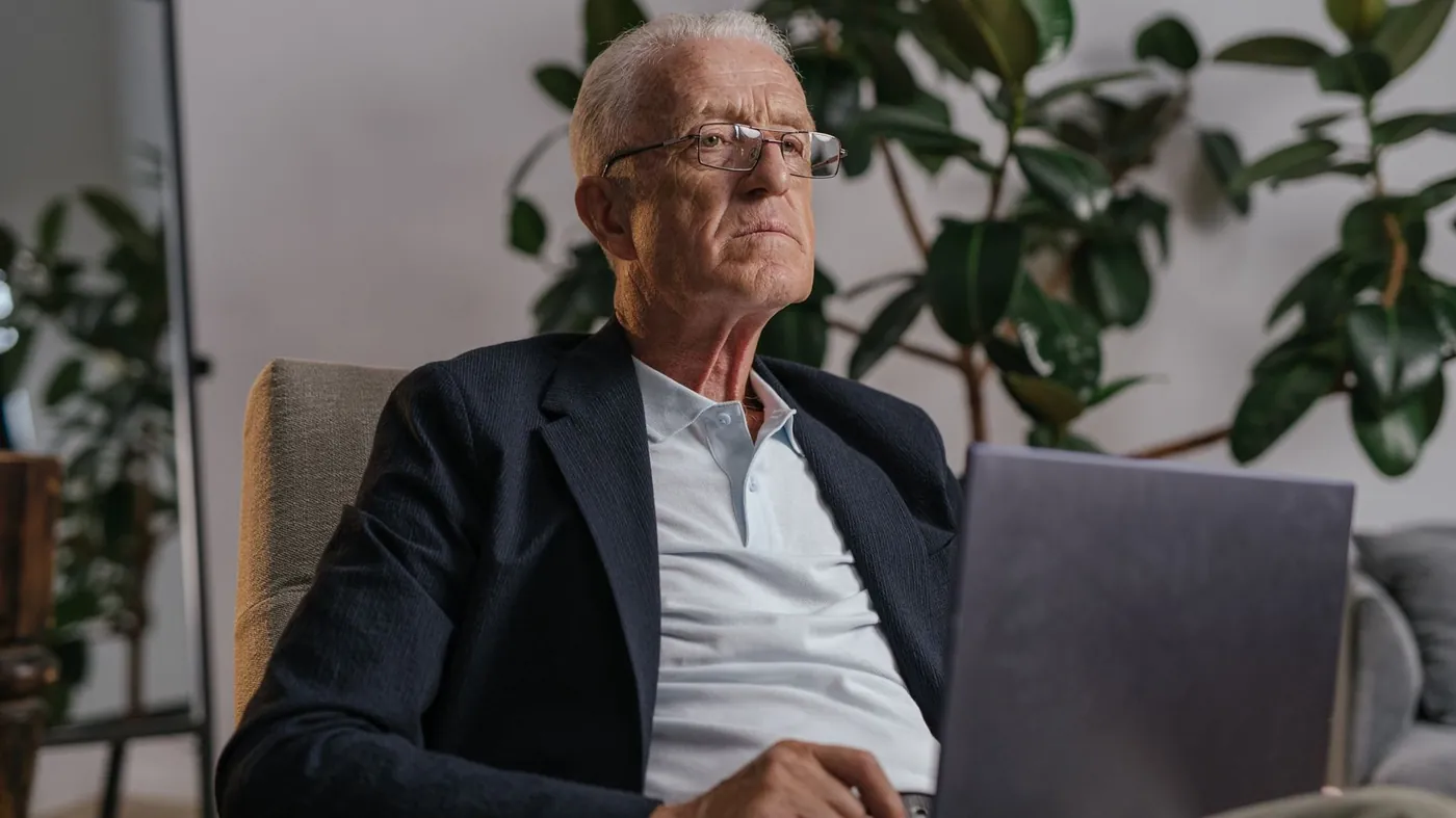 Älterer Mann im Sessel mit Laptop – Treppenlift gebraucht kaufen oder mieten vergleichen